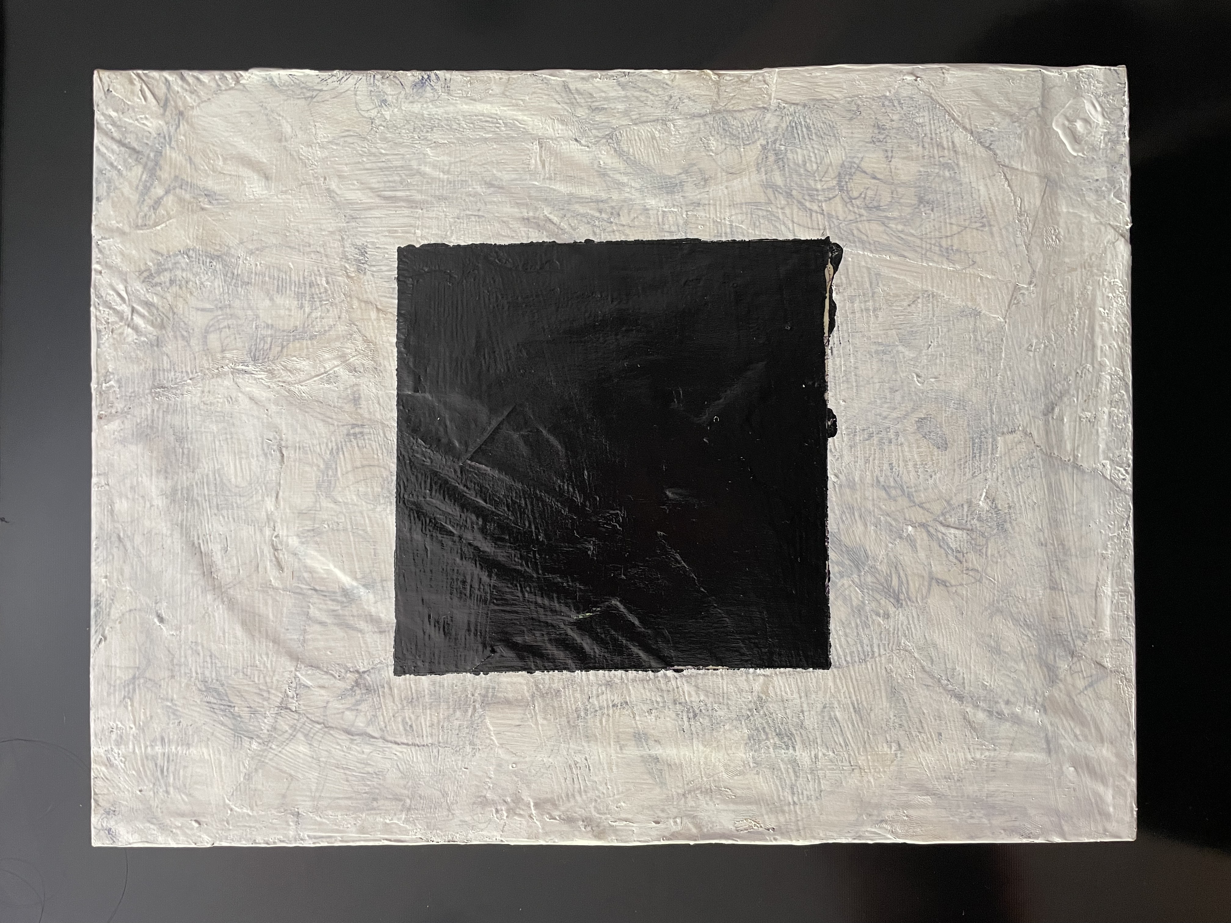 A black square over a translucent white background with bits of old sketches peeking through