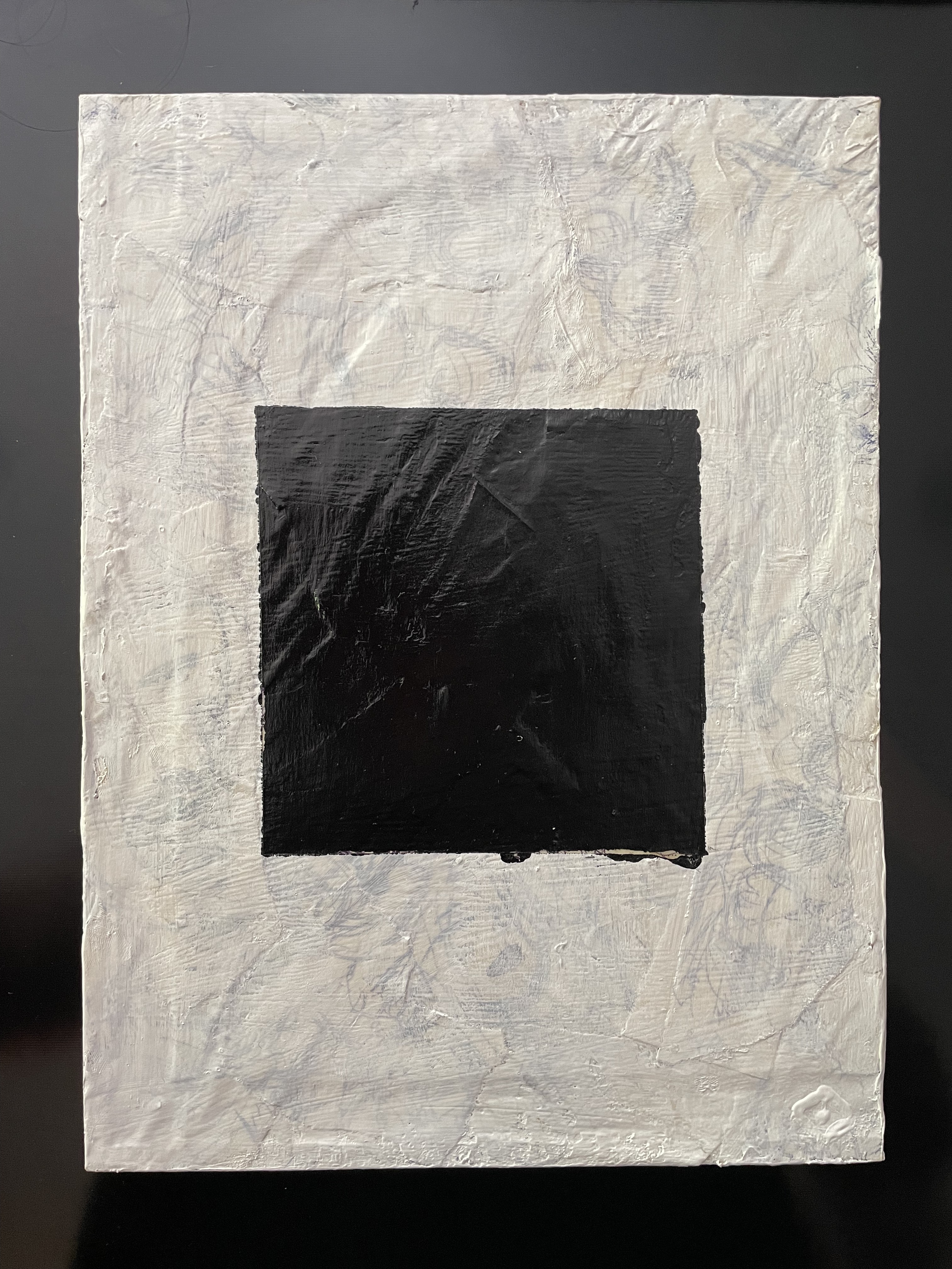 A black square over a translucent white background with bits of old sketches peeking through